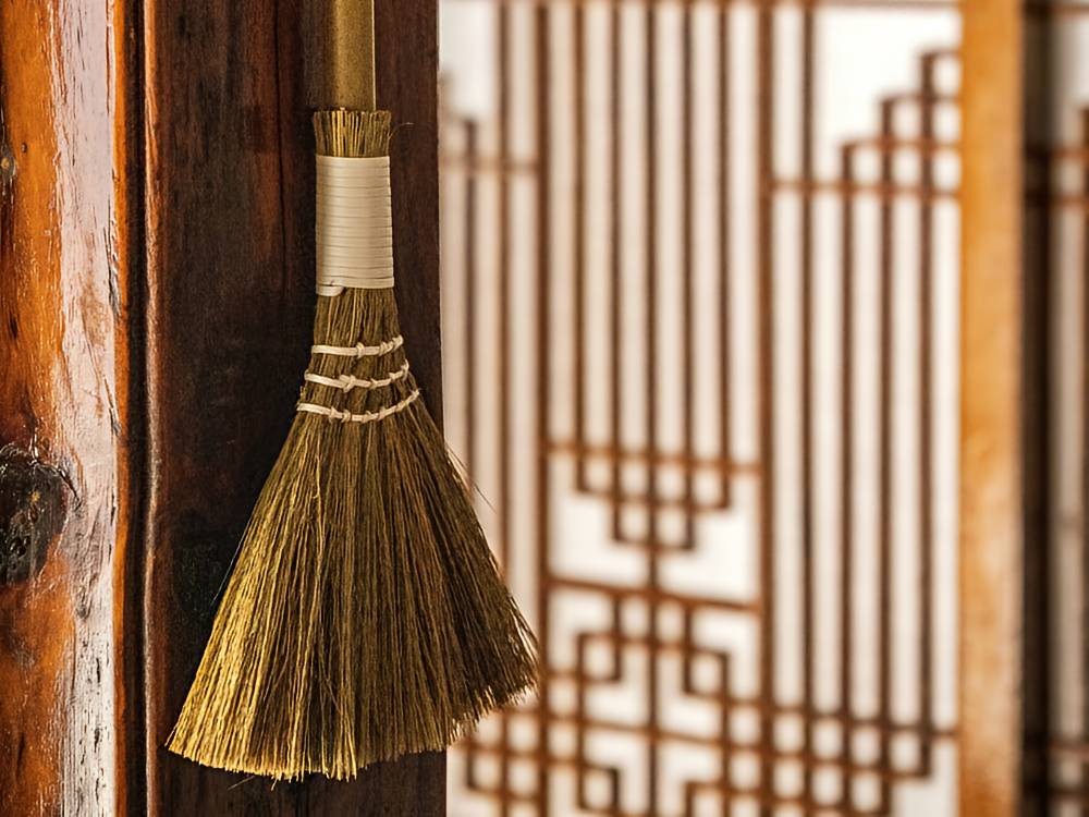 Korean straw broom hanging on wooden beam