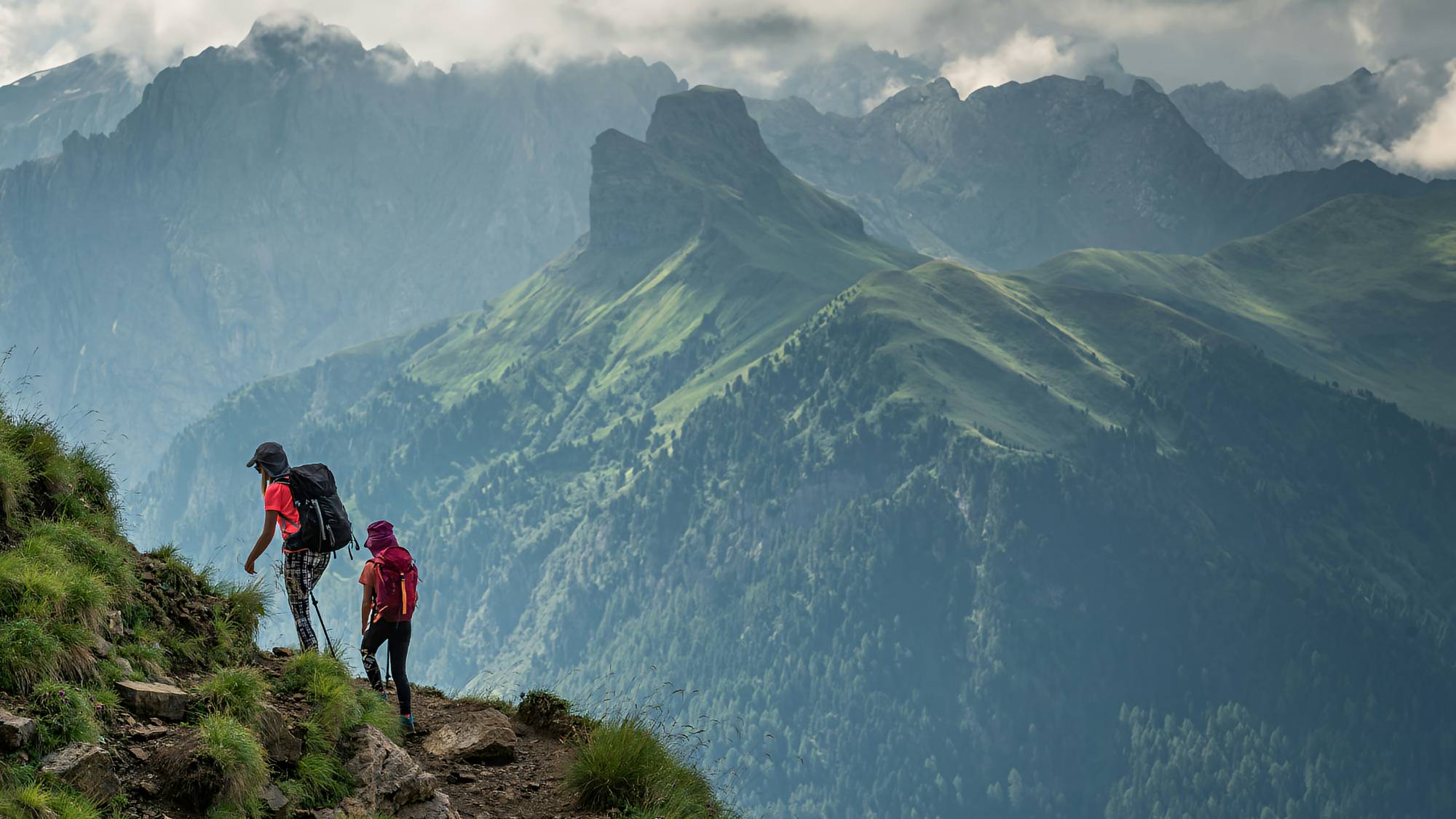 Two hikers trekking in the Dolomites mountains in Italy.
